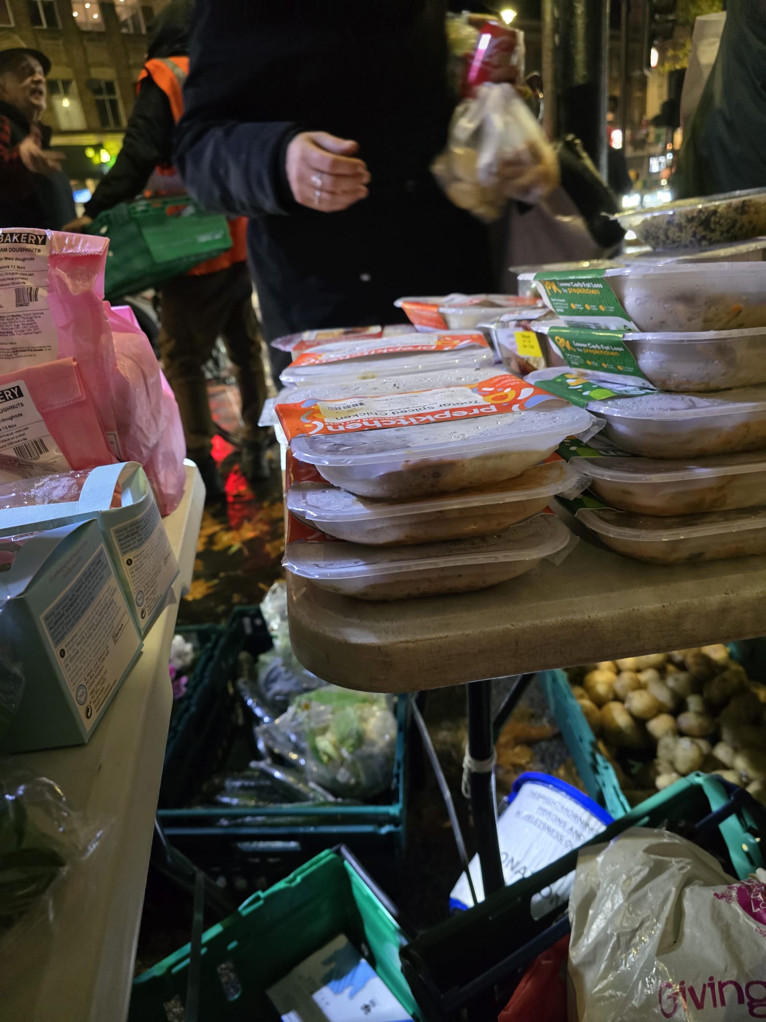 Full view of street outreach with volunteers distributing meals and groceries